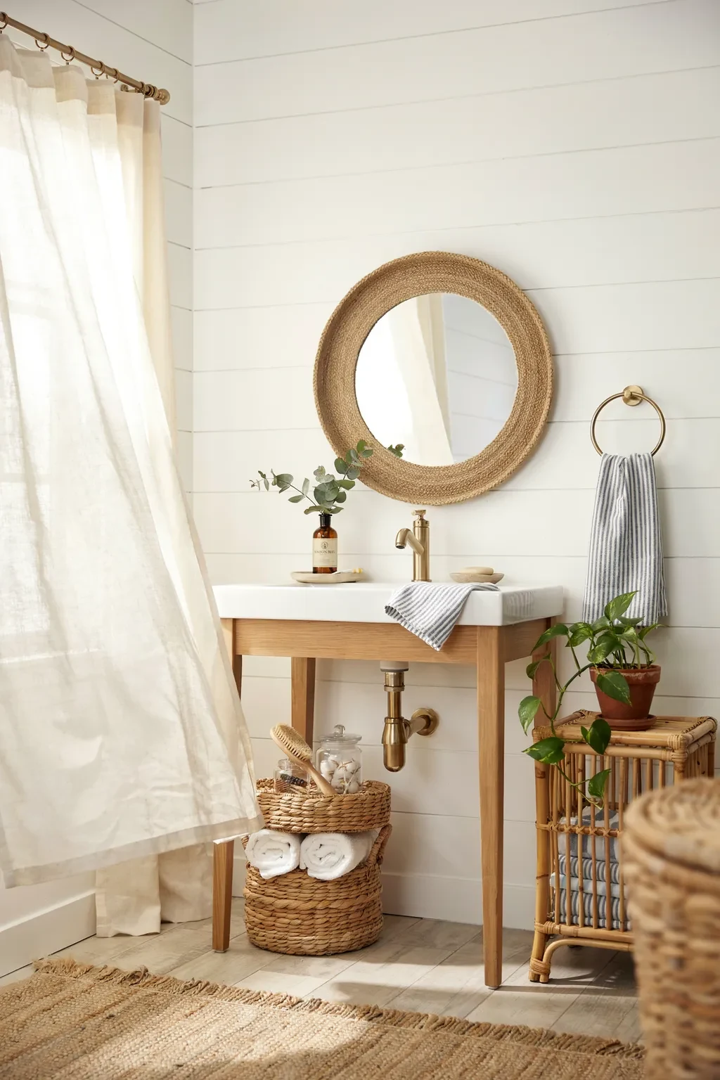 Bright coastal farmhouse bathroom styled with woven seagrass baskets