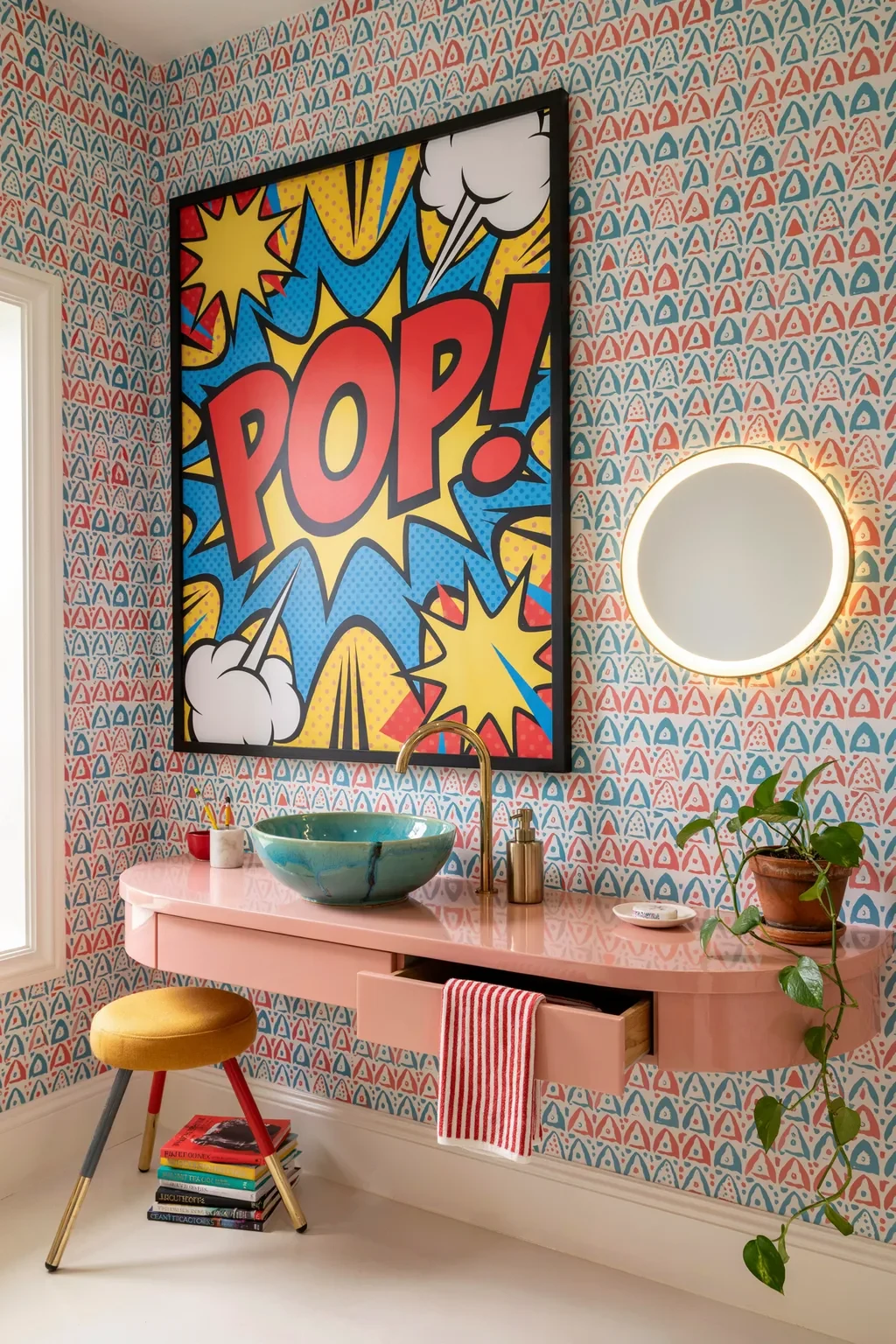 Funky bathroom with a bold POP art print over geometric wallpaper and a pink vanity
