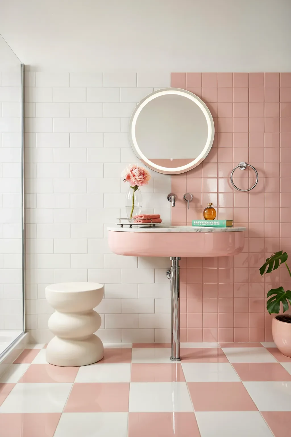 Bold two-tone pink and white tile bathroom with a curvy pink sink and checkerboard floor