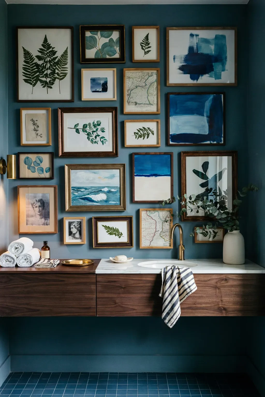 Moody blue bathroom gallery wall filled with botanical and abstract art